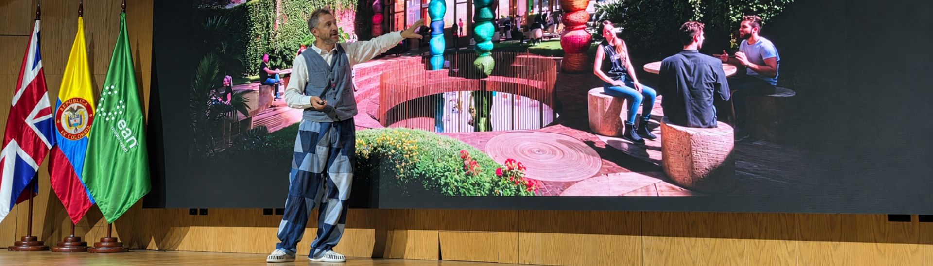 Thomas Heatherwick en el escenario de la Universidad Ean en Bogotá sosteniendo y presentando la edición en español de su libro Humanise.